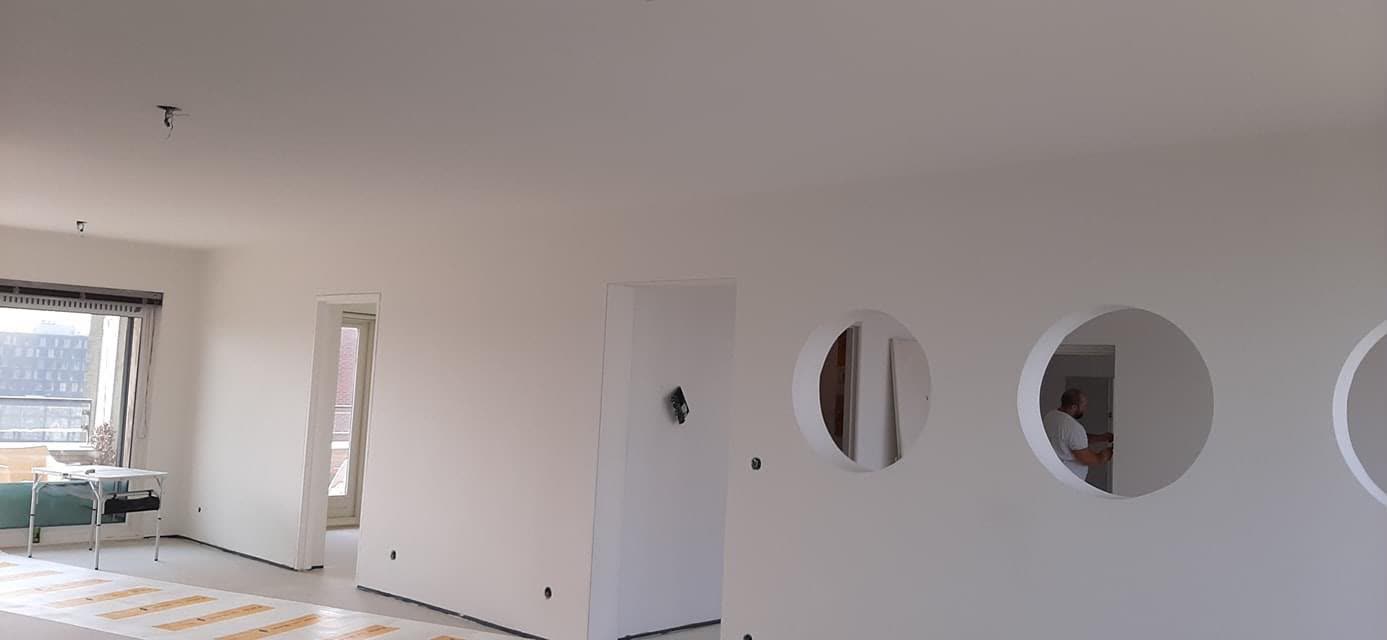 Gestucte en geschilderde wanden met ronde doorgangen in een appartement in Amsterdam