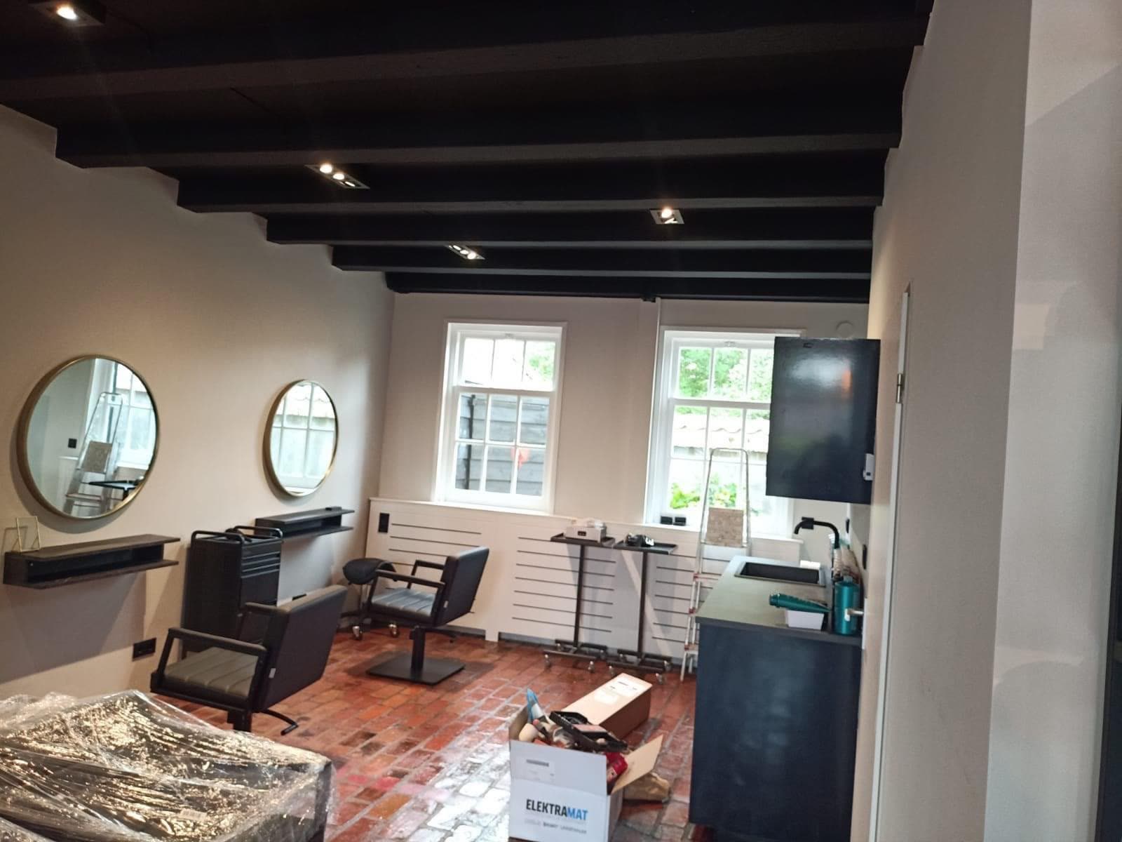 Afgewerkte wachtruimte van de kapsalon in Rotterdam na stuc- en spuitwerk